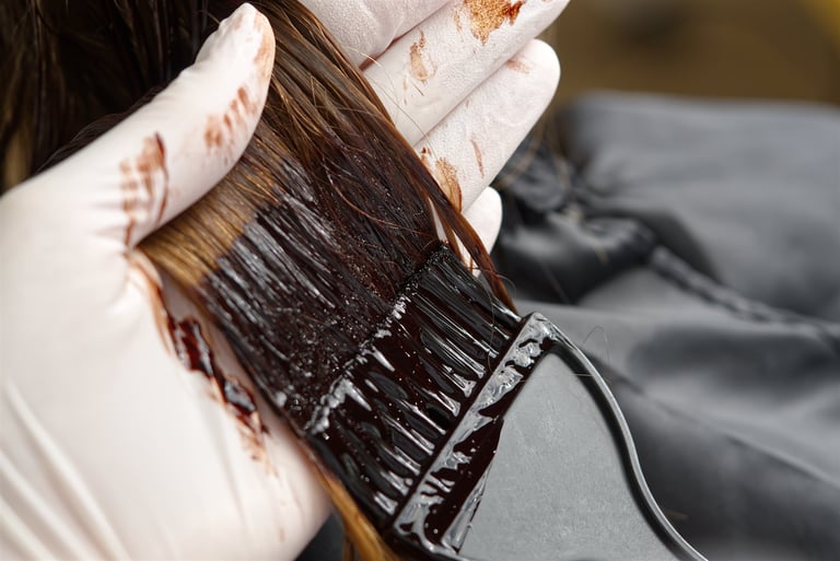 Hairdresser applying hair dye with brush