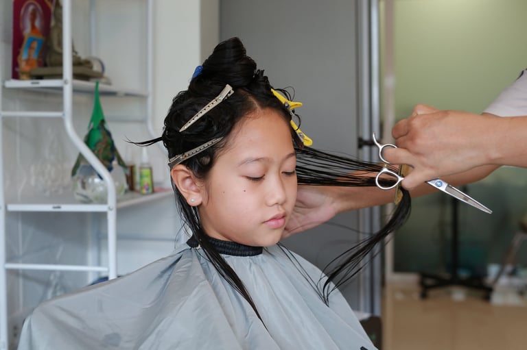 Asian child getting hair cut